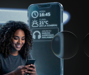 Mujer joven sonriendo mientras usa su smartphone, con una interfaz digital flotante que muestra datos contextuales como hora (16:45), clima (21°C) y un anuncio personalizado de audífonos. Estilo futurista de marketing contextual.