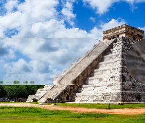 Pirámide de Kukulcán en Chichén Itzá bajo un cielo azul con nubes, con un efecto de desenfoque artístico en primer plano.
