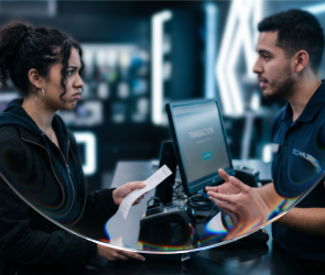 Clienta insatisfecha entrega un recibo a un empleado en el mostrador de una tienda, representando el momento post-venta que define la fidelización de clientes