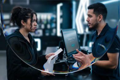 Clienta insatisfecha entrega un recibo a un empleado en el mostrador de una tienda, representando el momento post-venta que define la fidelización de clientes